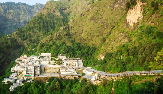 "A comfortable sedan taxi driving on a scenic road from the hills of Dharamshala to Jammu.